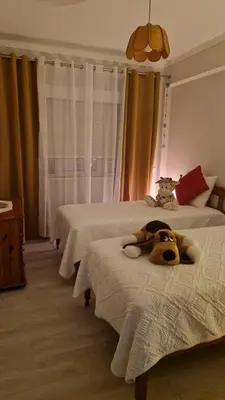 a stuffed animal laying on a bed in a bedroom at AREIAS SOL in Albufeira