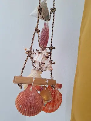 a hanging chandelier with seashells on a ceiling at AREIAS SOL in Albufeira