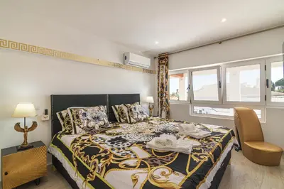 a bedroom with a large bed and a window at Flat with Pool T2 Duplex Montechoro in Albufeira