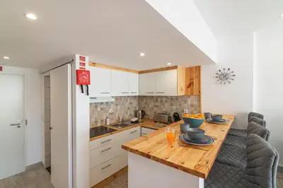 a kitchen with a wooden table and a counter top at Flat with Pool T2 Duplex Montechoro in Albufeira