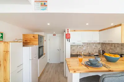 a kitchen with a wooden counter top in a room at Flat with Pool T2 Duplex Montechoro in Albufeira