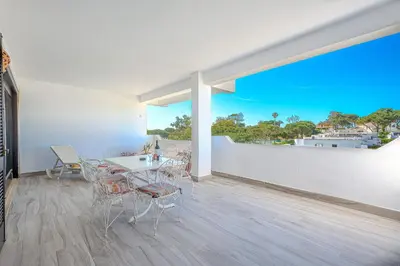 a dining room with a table and chairs and a large window at Apartamento Ivone by Sunnyway in Albufeira