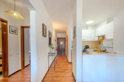 a kitchen with white cabinets and a long hallway at Apartamento Ivone by Sunnyway in Albufeira