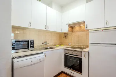 a kitchen with white cabinets and a sink at Apartamento Ivone by Sunnyway in Albufeira