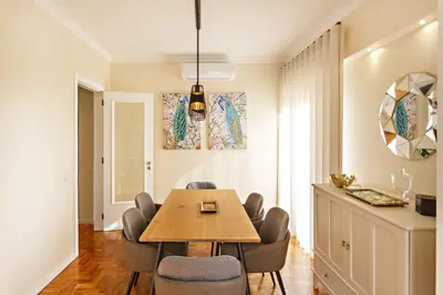 a dining room with a wooden table and chairs at Blue Peacock in Faro