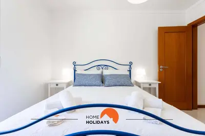 a bedroom with a white bed with a blue frame at #152 T1 Falésia by Home Holidays in Albufeira
