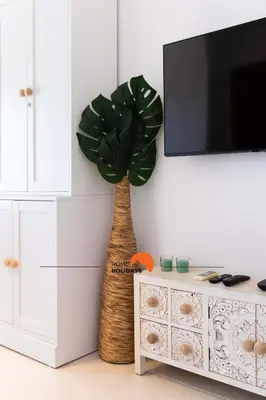 a plant in a living room next to a tv at #152 T1 Falésia by Home Holidays in Albufeira