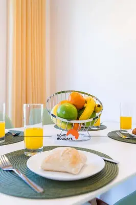 a table with a bowl of fruit and a plate of food at #152 T1 Falésia by Home Holidays in Albufeira