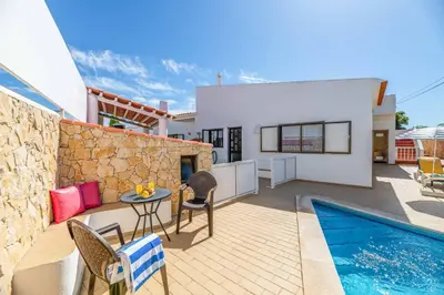 a patio with a table and chairs and a swimming pool at Villa Mar do Estrela in Galé