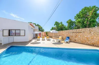 a house with a swimming pool and a stone wall at Villa Mar do Estrela in Galé