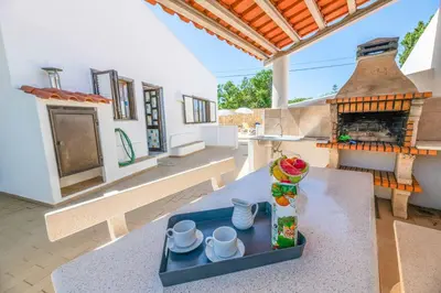 a living room with a table and a fireplace at Villa Mar do Estrela in Galé