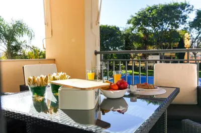 a table with food and drinks on a balcony at Apartment - Vilamoura Pine By Dalma Portuguesa in Quarteira