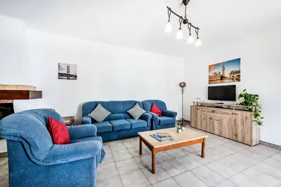 a living room with a blue couch and a tv at Villa Mendes in Vilamoura