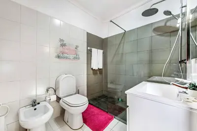 a white bathroom with a toilet and a sink at Villa Mendes in Vilamoura
