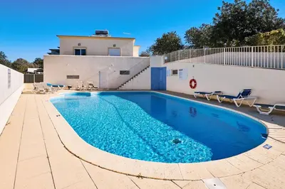 a swimming pool with blue water in front of a building at NEU - Casa Tina mit Meerblick und Pool in Guia