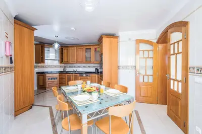 a kitchen with a table and some chairs in it at Villa Encosta do Sol in Albufeira