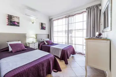 a hotel room with two beds and a window at Villa Encosta do Sol in Albufeira