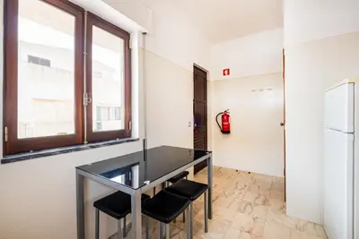 a glass table with black chairs in a room with a fire hydrant at Mar&Mar Old Town 2 Bedroom Apartment in Albufeira