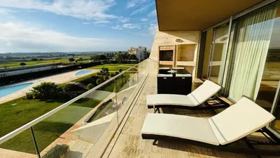a balcony with white chairs and a view of the ocean at Two Bedroom Laguna Village - By Vilamoura Sun in Quarteira
