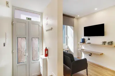 a living room with a door and a tv at Bougainvillea House in Faro