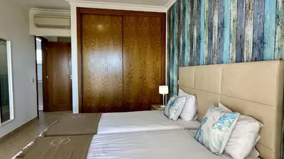 a bedroom with a large bed and a wooden wall at Antonieta by Check-in Portugal in Albufeira