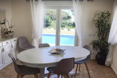 a white table and chairs in a kitchen with a window at Villa Daffodil Golf in Vilamoura