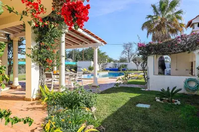 a house with a yard with a pool and flowers at Villa Mica in Azinhal