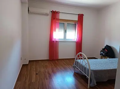 a bedroom with a bed and a window with red curtains at Holiday HouseV5 W/Pool & BBQ in Albufeira