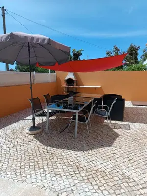 a table and chairs with an umbrella on a patio at Holiday HouseV5 W/Pool & BBQ in Albufeira