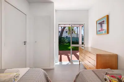 a bedroom with a bed and a dresser and a window at Villa Lynn - Quadradinhos in Almancil