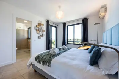 a bedroom with a large bed and a bathroom at Casa Esmarand in Albufeira