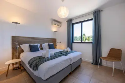 a bedroom with a large bed and a window at Casa Esmarand in Albufeira