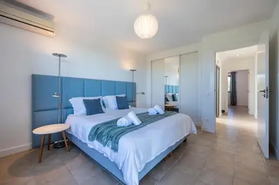 a bedroom with a large bed with a blue headboard at Casa Esmarand in Albufeira