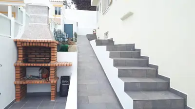 a patio with a fireplace on the side of a building at Marina Vila Apartment with Pool in Albufeira
