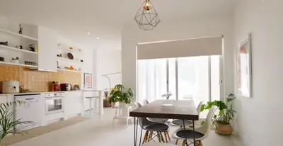 a white kitchen with a table and chairs in it at Casa Longa Faro - Traditional Portuguese House with modern comforts in Faro