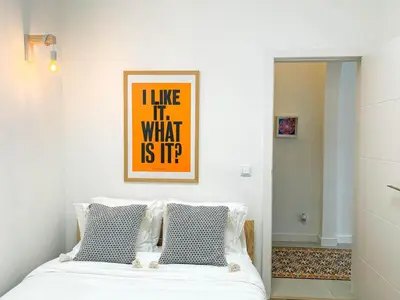a bedroom with a bed with a picture on the wall at Casa Longa Faro - Traditional Portuguese House with modern comforts in Faro