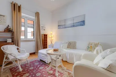 a living room with a white couch and a table at Casa LOTUS - Requinte e bom gosto para 6 pessoas no coração de Faro in Faro