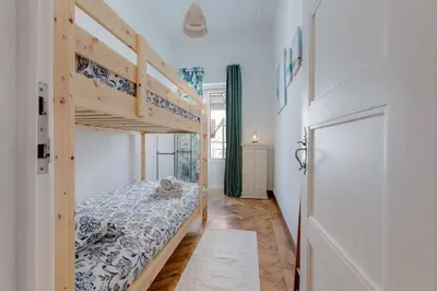 a bedroom with two bunk beds and a door at Casa LOTUS - Requinte e bom gosto para 6 pessoas no coração de Faro in Faro
