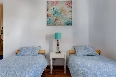 two beds sitting next to each other in a bedroom at Casa LOTUS - Requinte e bom gosto para 6 pessoas no coração de Faro in Faro