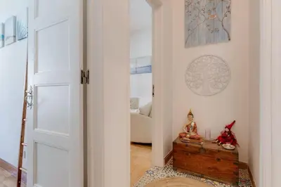 a hallway with a door leading into a living room at Casa LOTUS - Requinte e bom gosto para 6 pessoas no coração de Faro in Faro