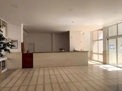 a lobby with a counter in a building with windows at Discovery Apartment Vilamoura in Vilamoura