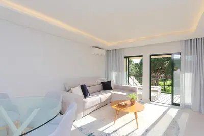 a living room with a white couch and a glass table at Birdie Bliss Apartment - CleverDetails - Sleeps 4 Adults and 1 Child in Vilamoura
