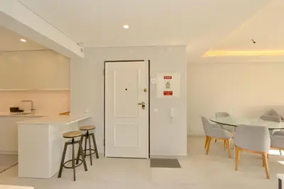 a kitchen and dining room with a white door and a table at Birdie Bliss Apartment - CleverDetails - Sleeps 4 Adults and 1 Child in Vilamoura