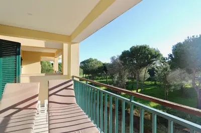 a balcony with two chairs and a view of a park at Birdie Bliss Apartment - CleverDetails - Sleeps 4 Adults and 1 Child in Vilamoura