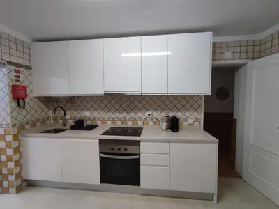a kitchen with white cabinets and a stove at Casa da Madalena in Faro