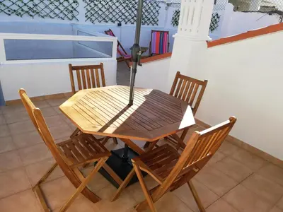 a dining room table with chairs and an umbrella at Casa da Madalena in Faro