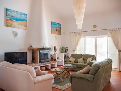 a living room with two couches and a fireplace at Beach villa Casa de Amanhã 450 mts to the beach with beautiful garden and heated saltwater pool in Albufeira
