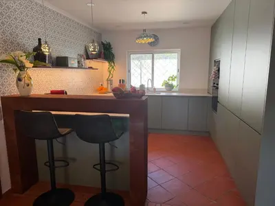 a bedroom with a white bed with a green pillow at Beach villa Casa de Amanhã 450 mts to the beach with beautiful garden and heated saltwater pool in Albufeira