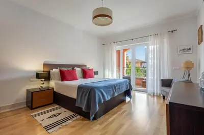 a swimming pool with two chairs and two swimming pools at Sunshine Vista Apartment Vilamoura in Vilamoura