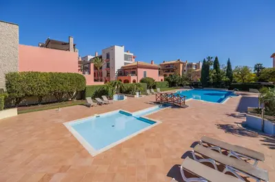 two beds in a bedroom with white walls and wooden floors at Sunshine Vista Apartment Vilamoura in Vilamoura